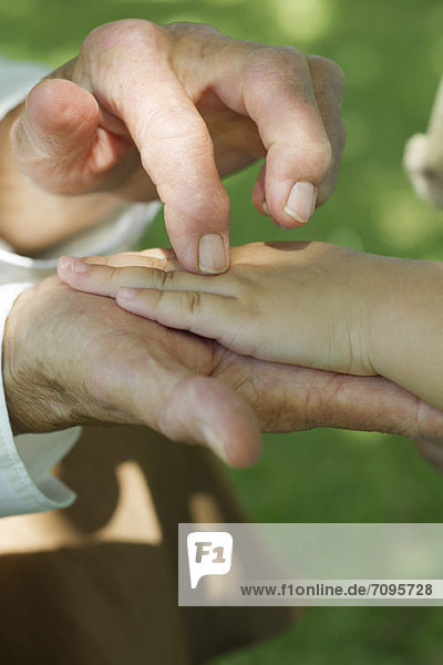 Elderly person holding child's hand  cropped