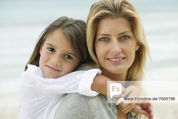 Mutter und Tochter umarmen sich am Strand  Portrait