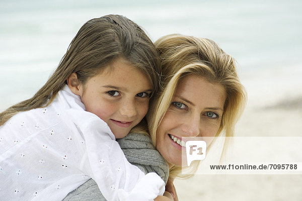 Mutter und Tochter umarmen sich am Strand  Portrait