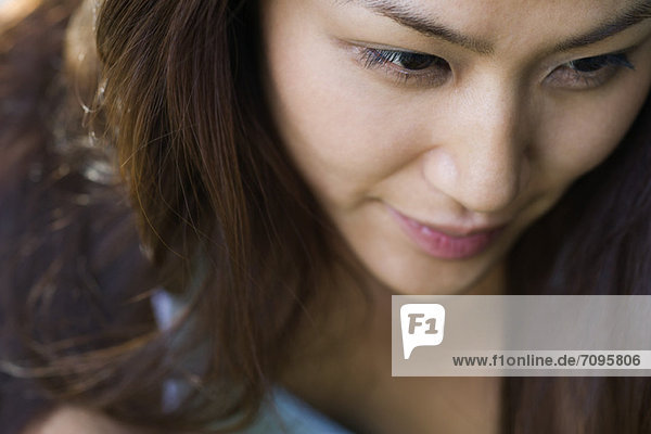 Young woman smiling  looking away in thought