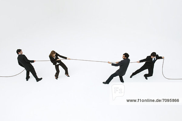 Business professionals playing tug-of-war