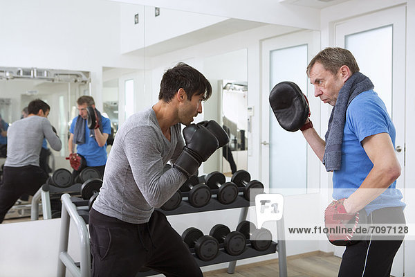 Boxerübungen mit Trainer im Fitnessstudio