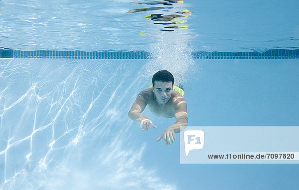 Teenager-Junge schwimmt unter Wasser