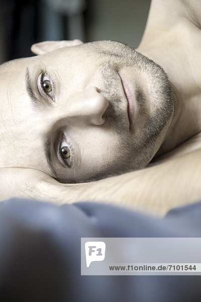 Man with designer stubbles lying in bed  portrait
