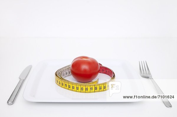 Plate with tomato and tape measure