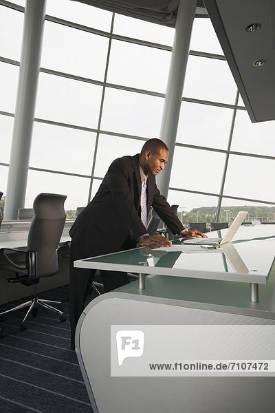 Black businessman using laptop in conference room