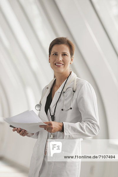 Smiling Caucasian doctor standing in hospital corridor