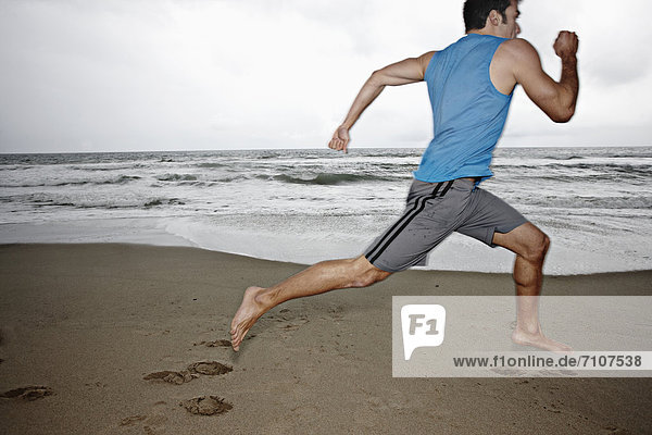 Young man running on beach