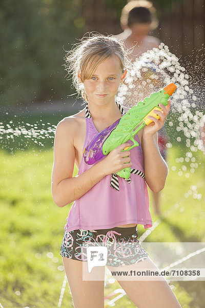 Caucasian girl holding a water gun