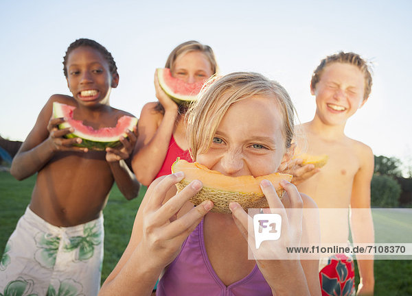Children eating cantaloupe and watermelon