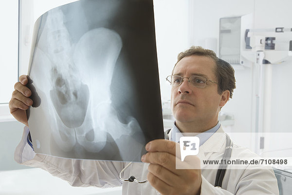 Caucasian doctor looking at hip x-ray