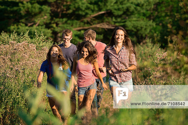 Five friends walking through field