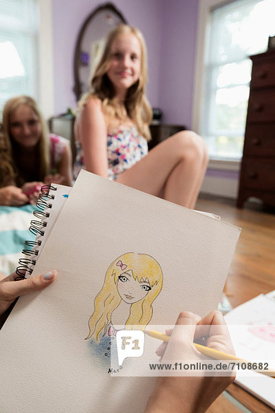 Girl Zeichnung Porträt eines Freundes auf dem Notebook