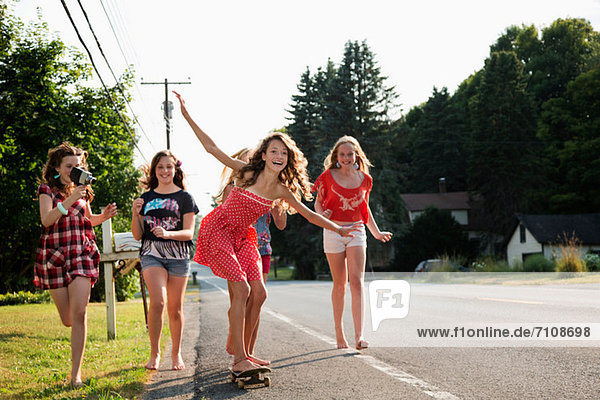 Mädchen auf Skateboard mit Freunden
