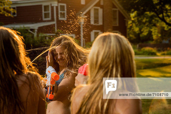 Girls having water fight with water pistols