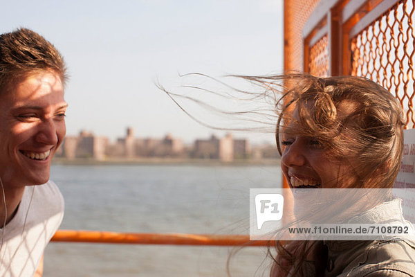 Young couple on a ferry  wind blowing hair