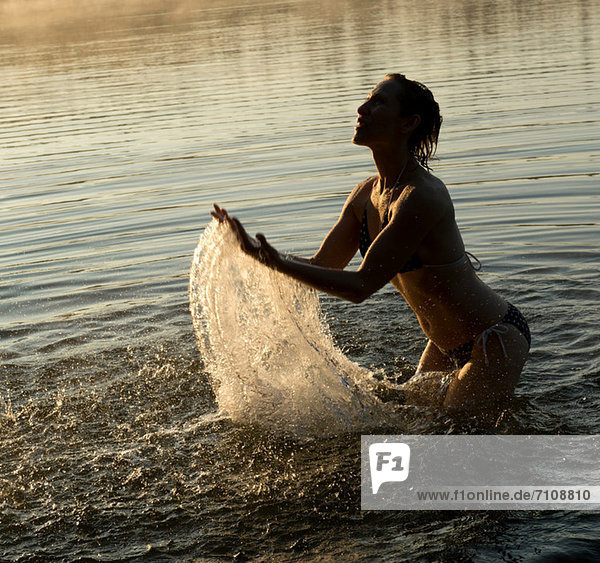 Frau spritzt im Wasser des Sees
