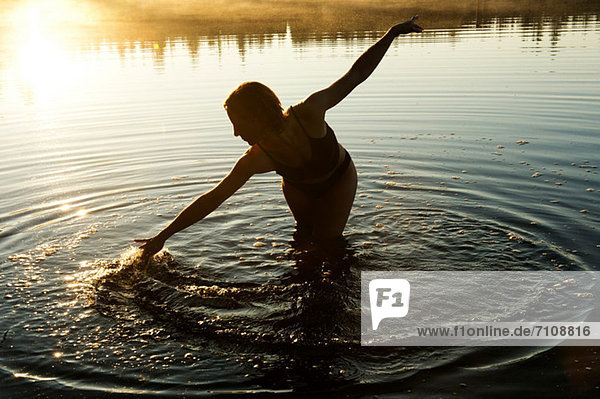 Frau berührt Wasser im See