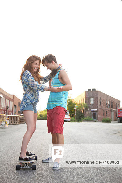 Young woman on skateboard with boyfriend