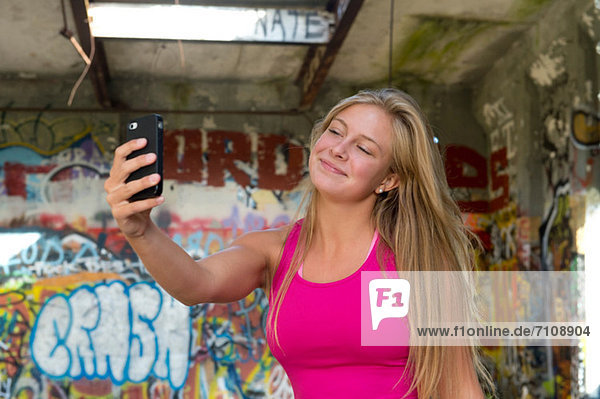 Teenagermädchen macht ein Foto von sich selbst auf dem Smartphone