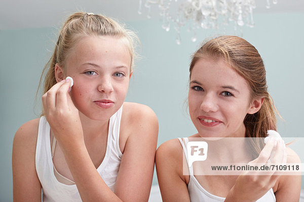 Teenagermädchen reinigen ihre Gesichter