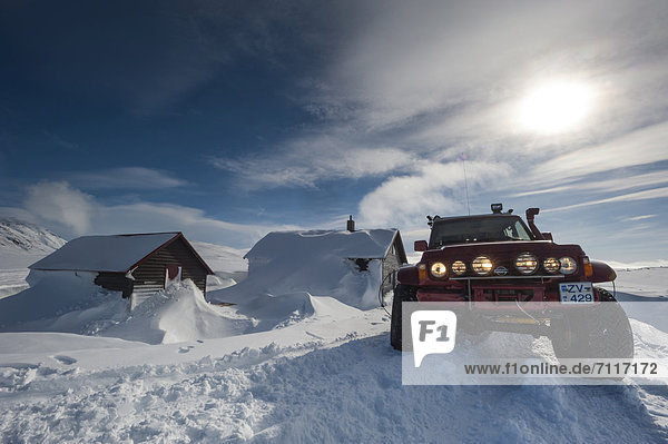 Super Jeep in front of the snow-covered N_idalur Huts  Vatnajoekull Glacier  Icelandic Highlands  Iceland  Europe