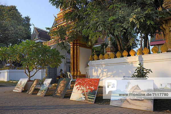 Paintings of tourist sights of the city positioned along a wall of the Chan Temple in Vientiane  Laos  Southeast Asia  Asia