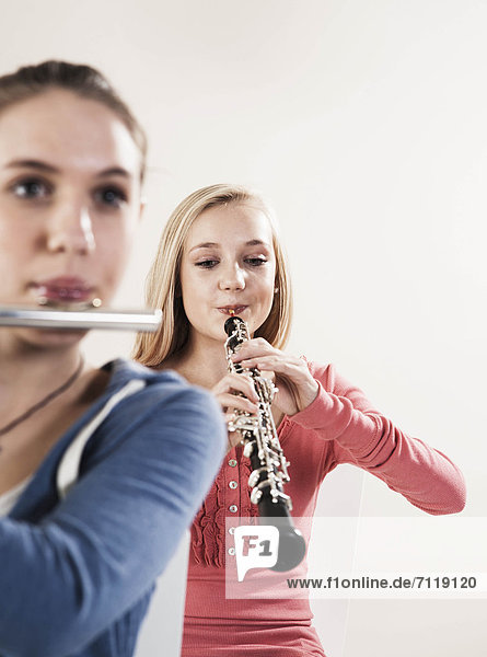 Zwei Teenagerinnen spielen Oboe und Querflöte