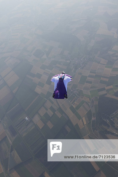 Fallschirmspringer mit Wingsuit in der Luft  Waadt  Schweiz