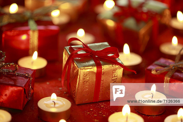 Decoration  present  presents  candle  candles  light  close-up  parcel  packet  Star  Stars  mood  studio  tealights  Christmas decoration  Christmas  Christmas decoration  mood  winter  decorative  elegant  gold  red  silver  atmospheric  surprise