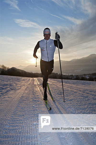 Wintersport  Winter  Mann  Sport  Morgen  Skisport  Ski  Langlaufski  Ramsau bei Berchtesgaden  Österreich  Abenddämmerung  Dämmerung