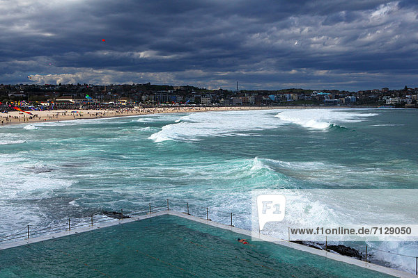 Festival of  wind  dragons  kites  aircraft  fun  Bondi Beach  Sydney  beach  seashore  steering dragon  wind  waves  clouds  party  fête  family  Australia  New South Wales  bright  sky  pool  water  swim  sombre  gloomy  Bondi of mountain Ice club  cult  sport  actively