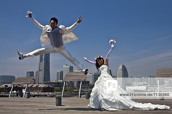 Skyline  Skylines  Frau  Mann  Fröhlichkeit  Hochzeit  Urlaub  Reise  Großstadt  springen  Asien  Japan  Yokohama