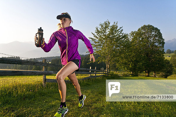 Frau  Sport  gehen  folgen  Gesundheit  rennen  Wiese  trinken  Ramsau bei Berchtesgaden  Österreich  Flasche