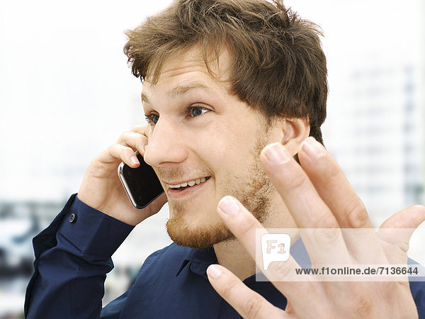 Portrait of a businessman making a telephone call  gesticulating  friendly  optimistic
