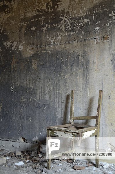 Zerbrochener Stuhl in einem heruntergekommenen Gebäude