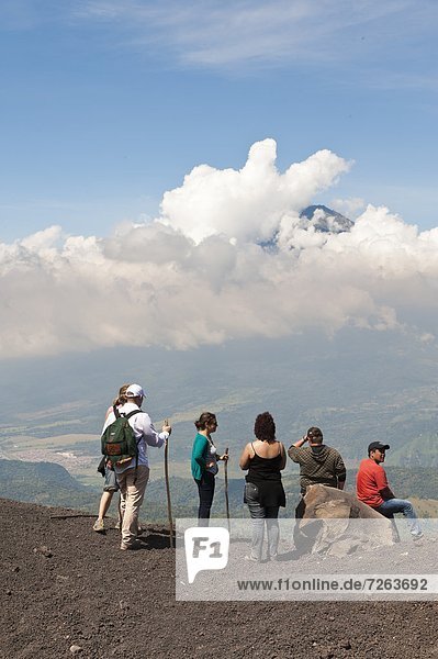 Climbing Pacaya volcano  with Fuego Volcano in distance Antigua  Guatemala  Central America
