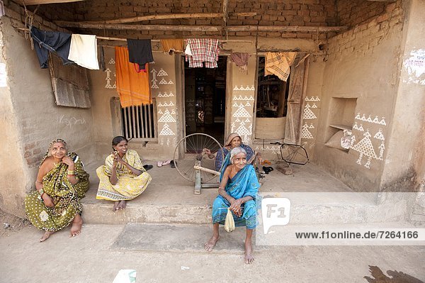 Women sitting chatting on verandah  painted with traditional Orissa patterns in rice flour  Naupatana weaving village  Orissa  India  Asia