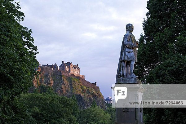 Statue of Allan Ramsay  with Edinburgh Castle at sunset from West Princes Street Gardens  Edinburgh  Scotland  United Kingdom  Europe