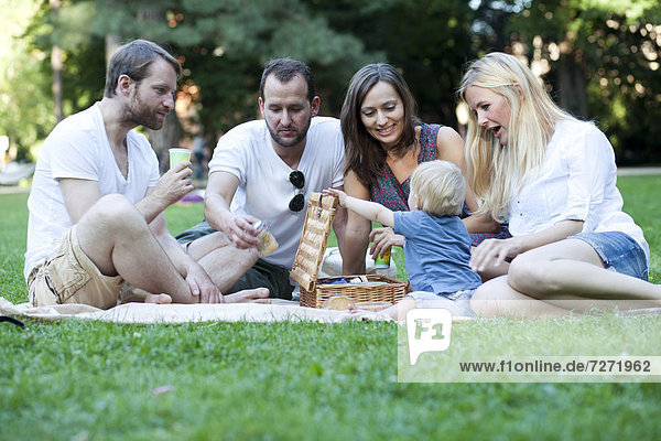 Picknick mit Freunden und Kleinkind im Park