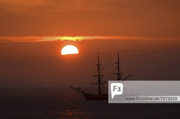 Silhouette eines Segelbootes mit Sonnenaufgang  in der Nähe von Port-Haliguen auf der Ostseite der Halbinsel Quiberon  südliche Bretagne  Bretagne  Frankreich  Europa