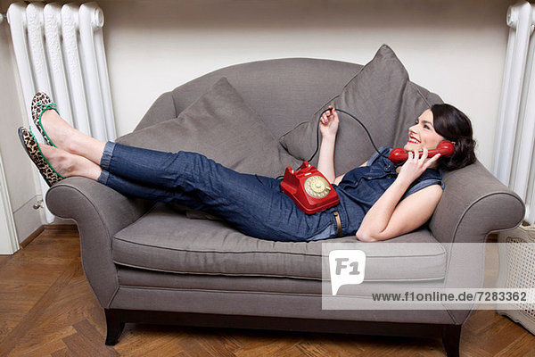 Frau auf dem Sofa am Telefon