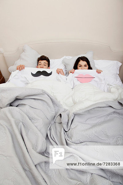 Couple in bed with lips and moustache mouth