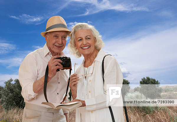 Seniorenpaar erkundet Landschaft mit Kamera