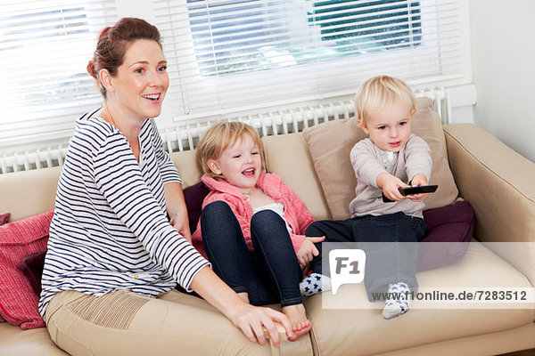 Mutter mit zwei Kindern beim Fernsehen