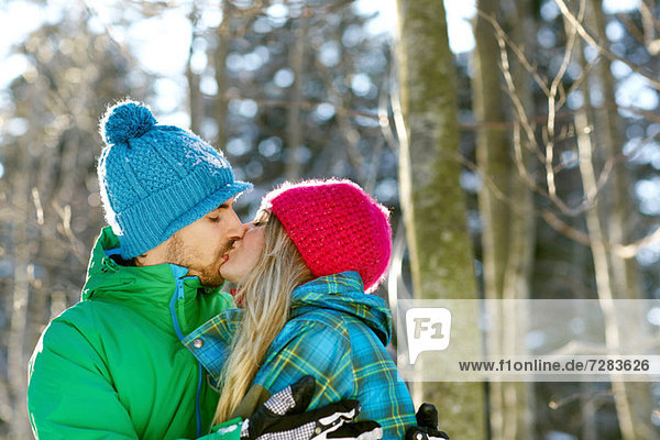Couple wearing knit hats  kissing