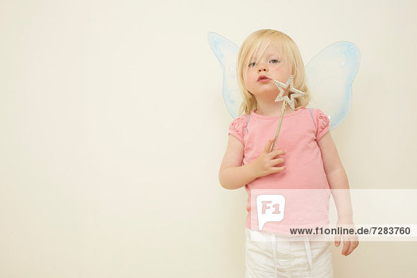 Toddler wearing wings  holding wand