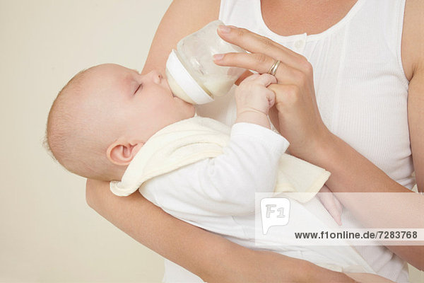 Mutter füttert neugeborene Babyflasche mit Babymilch