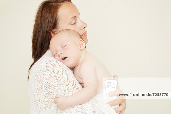 Mutter mit neugeborenem Baby schlafend auf der Schulter