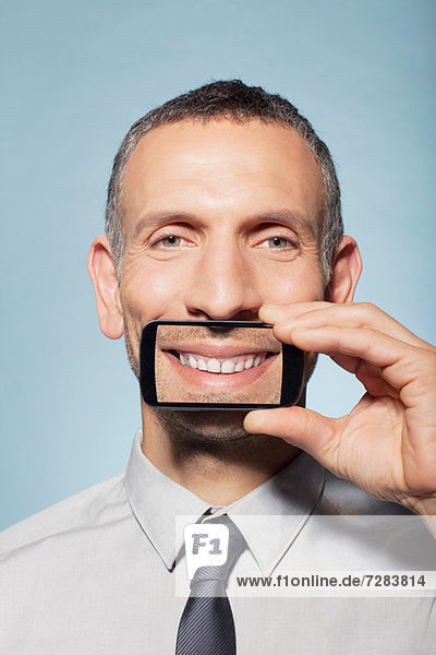 Man covering mouth with smartphone